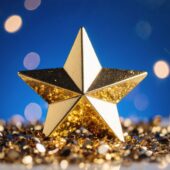 A golden star resting among shiny metallic confetti, symbol of success, victory, and triumph. By Giuseppe Cammino - AdobeStock. AI-generated