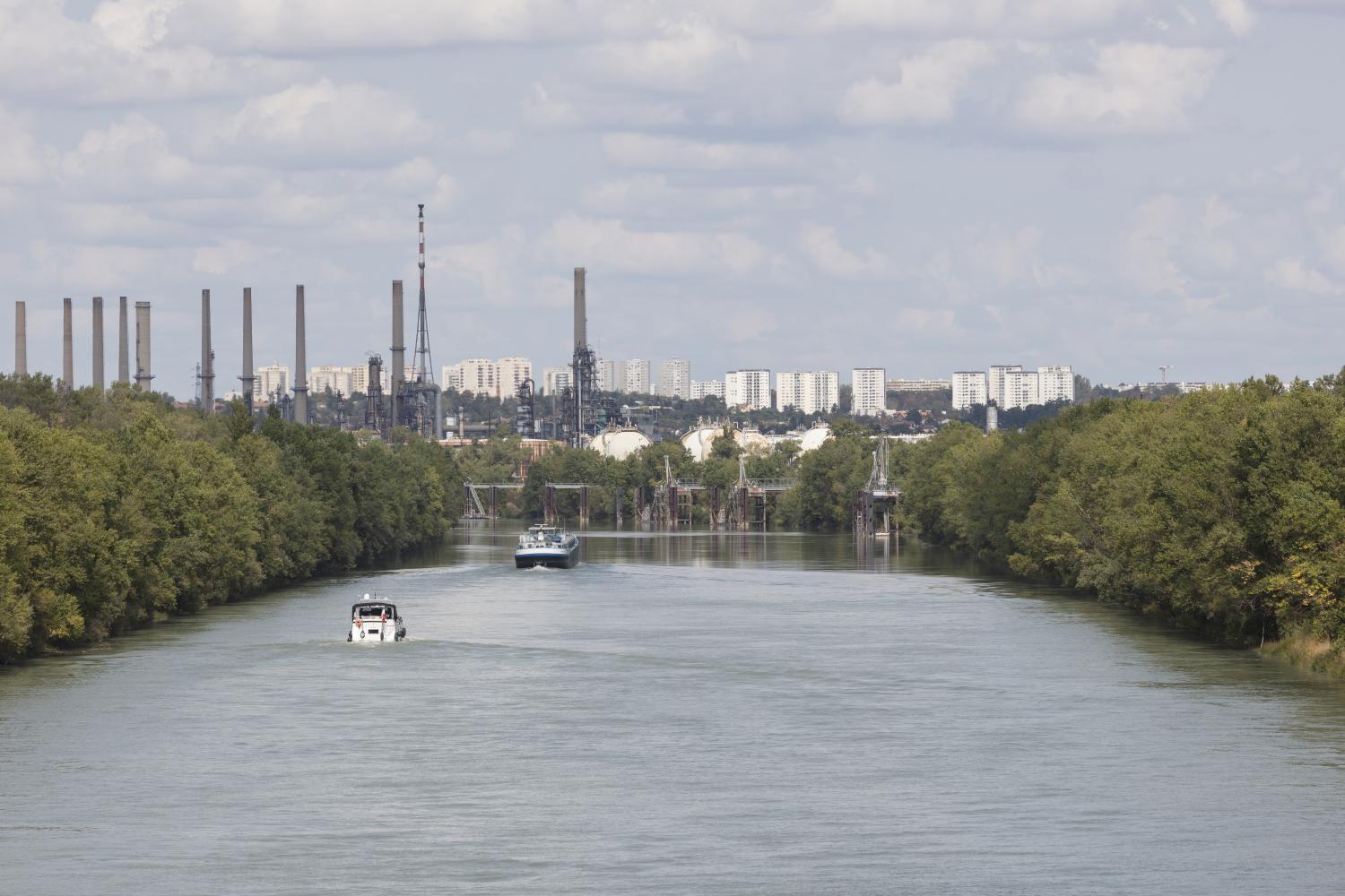 ue sur le canal de navigation du Rhône pour le transport fluvial - la raffinerie, puis les Minguettes en arrière-plan.