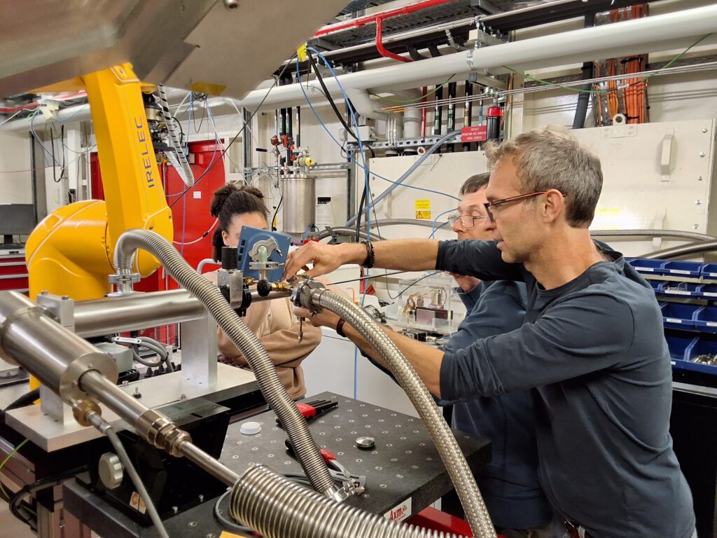 Insertion d'un échantillon au cours d'une expérience de diffraction des rayons X sur la ligne CRISTAL au synchrotron SOLEIL sur le site de l'université Paris-Saclay. De gauche à droite: Stéphane Pailhès, Erik Elkaïm et Chloé Andrade.