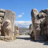 ruine du site de Hattusa, corridor à ciel ouvert échelonné par plusieurs portes dont la première est décorée par deux têtes et avant-corps de lions sculptés dans des blocs de pierre