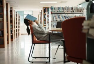 Asian student woman read books in library at university. Young girl stress tired have problem while study hard. Sadness concept. By Thanumporn - AdobeStock